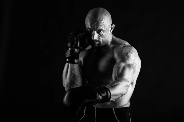 Культурист в боксёрских перчатках на черном фоне — стоковое фото
