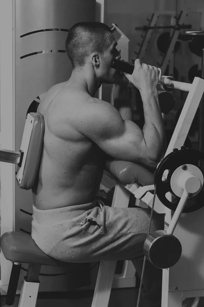 Actividades deportivas en el gimnasio. Hombre fuerte haciendo ejercicios —  Fotos de Stock