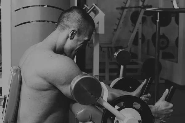 Actividades deportivas en el gimnasio. Hombre fuerte haciendo ejercicios —  Fotos de Stock