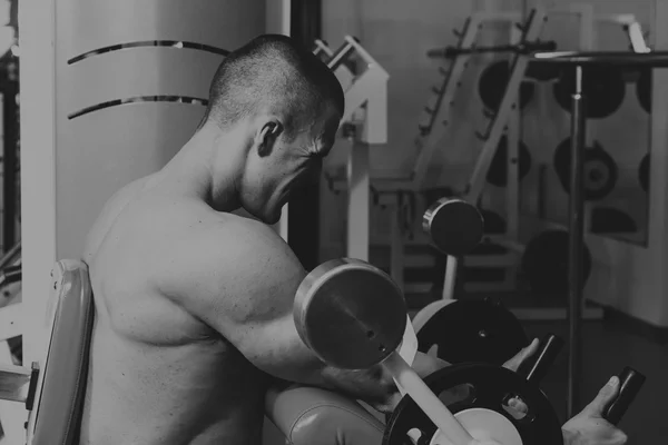 Actividades deportivas en el gimnasio. Hombre fuerte haciendo ejercicios — Foto de Stock