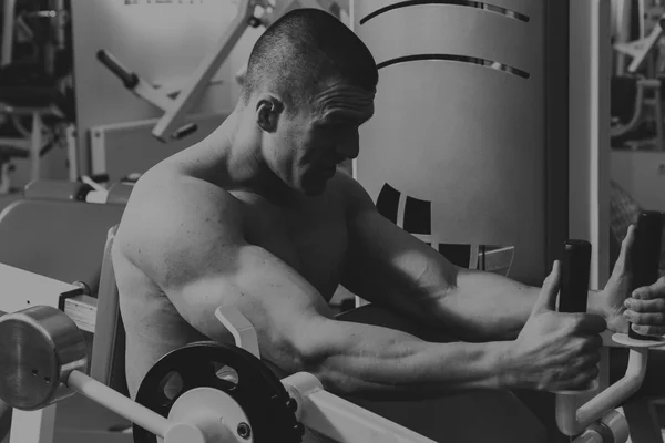 Actividades deportivas en el gimnasio. Hombre fuerte haciendo ejercicios —  Fotos de Stock