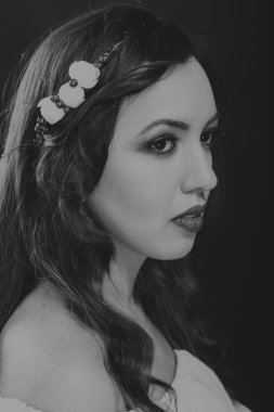 Karanlık bir arka plan üzerinde güzel, gizemli, şirin esmer. Siyah ve beyaz fotoğraf güzel gizemli esmer.