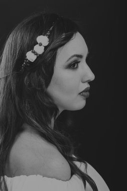 Karanlık bir arka plan üzerinde güzel, gizemli, şirin esmer. Siyah ve beyaz fotoğraf güzel gizemli esmer.