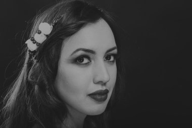 Karanlık bir arka plan üzerinde güzel, gizemli, şirin esmer. Siyah ve beyaz fotoğraf güzel gizemli esmer.