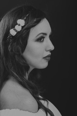Karanlık bir arka plan üzerinde güzel, gizemli, şirin esmer. Siyah ve beyaz fotoğraf güzel gizemli esmer.