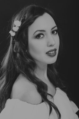 Karanlık bir arka plan üzerinde güzel, gizemli, şirin esmer. Siyah ve beyaz fotoğraf güzel gizemli esmer.