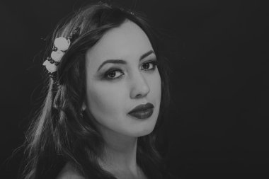 Karanlık bir arka plan üzerinde güzel, gizemli, şirin esmer. Siyah ve beyaz fotoğraf güzel gizemli esmer.