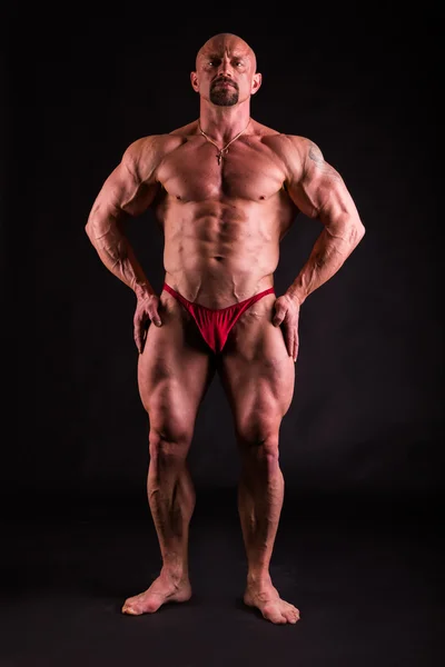 Bodybuilder dans des poses démonstratives sur noir — Photo