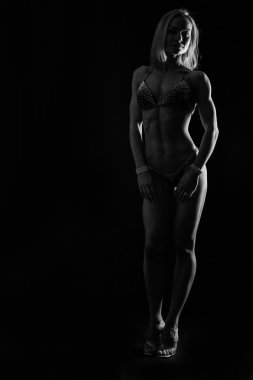 Zarif eğitim, kaslı kadın siyah bir zemin üzerine