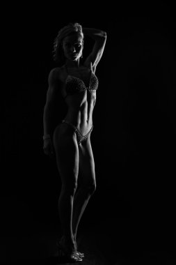 Zarif eğitim, kaslı kadın siyah bir zemin üzerine