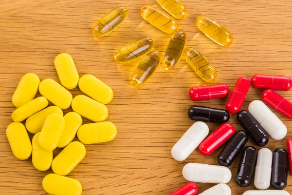 Different pills and pills on a wooden background — Stock Photo, Image