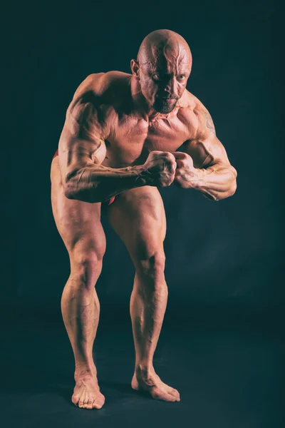 Bodybuilding, uomo forte su nero — Foto Stock