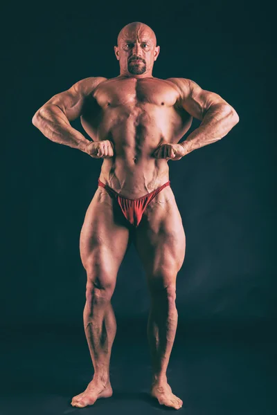 Bodybuilding, uomo forte su nero — Foto Stock