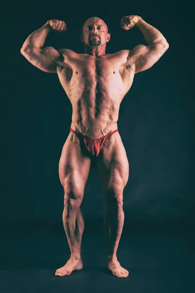 Musculación, hombre fuerte en negro —  Fotos de Stock
