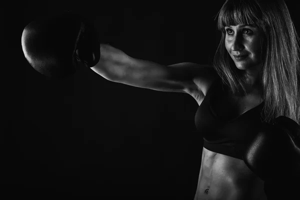 A menina com um corpo bonito treinado em luvas de boxe — Fotografia de Stock