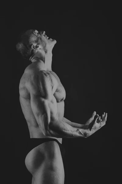 Känslomässiga bodybuilder på svart — Stockfoto