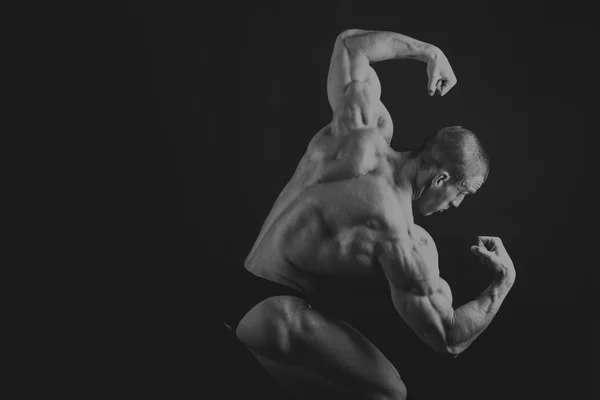 Känslomässiga bodybuilder på svart — Stockfoto