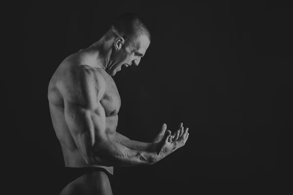 Emotional bodybuilder on black — Stock Photo, Image