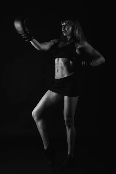 A menina com um corpo bonito treinado em luvas de boxe — Fotografia de Stock