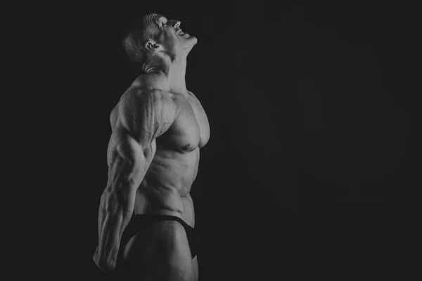 Emotional bodybuilder on black — Stock Photo, Image