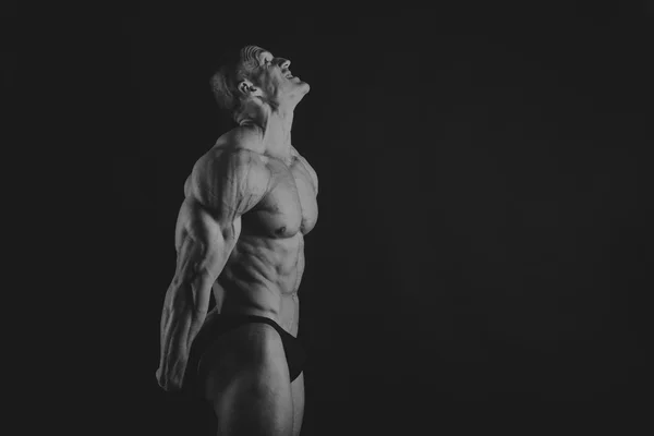 Emotional bodybuilder on black — Stock Photo, Image