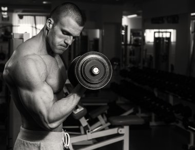 Eğitim dumbbells ile spor salonunda bir adamdır. Sağlıklı bir yaşam tarzı ve