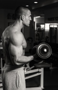 Eğitim dumbbells ile spor salonunda bir adamdır. Sağlıklı bir yaşam tarzı ve