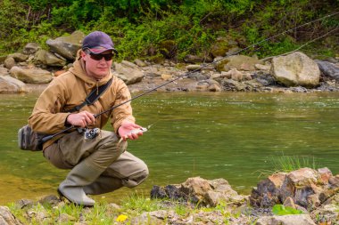 Bir balıkçı alabalık dağ Nehri üzerinde yakaladı.