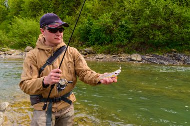 Bir balıkçı alabalık dağ Nehri üzerinde yakaladı.