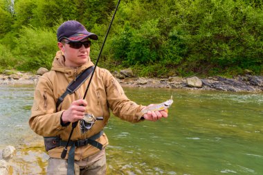 Bir balıkçı alabalık dağ Nehri üzerinde yakaladı.
