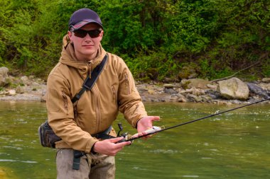 Bir balıkçı alabalık dağ Nehri üzerinde yakaladı.