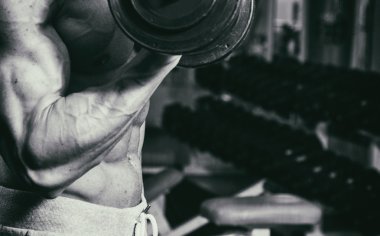 Spor salonunda dumbbells ile bir meslek. Güçlü adam dumbbells ile