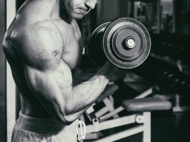 Spor salonunda dumbbells ile bir meslek. Güçlü adam dumbbells ile