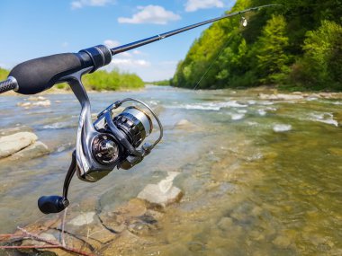 Gölde balık tutma. İplik makarası ve göl bir arka plan üzerinde