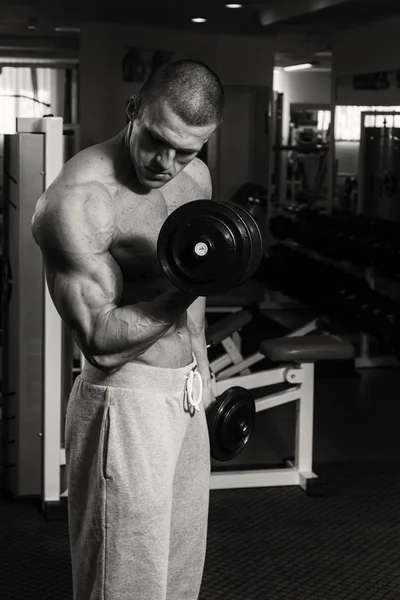 Un homme s'entraîne au gymnase avec des haltères. Un mode de vie sain et — Photo