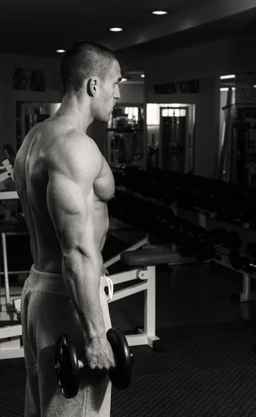 Ein Mann trainiert im Fitnessstudio mit Hanteln. einen gesunden Lebensstil und — Stockfoto