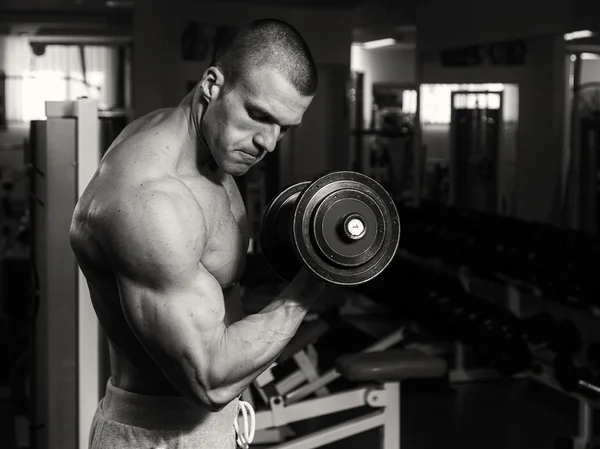 Un hombre está entrenando en gimnasia con pesas. Un estilo de vida saludable y —  Fotos de Stock