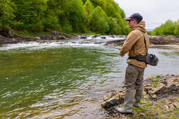 Um pescador pegou truta no rio da montanha — Fotografia de Stock