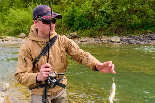 Un pescador pescó trucha en el río de la montaña —  Fotos de Stock