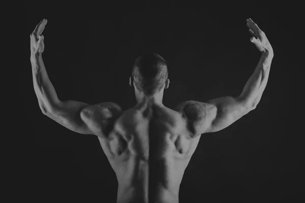 肌肉发达，救济身体健美运动员在黑色背景上。黑色 — 图库照片
