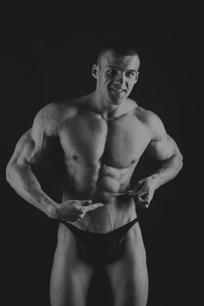 Muscoloso, bodybuilder sollievo su uno sfondo nero. Nero a — Foto Stock