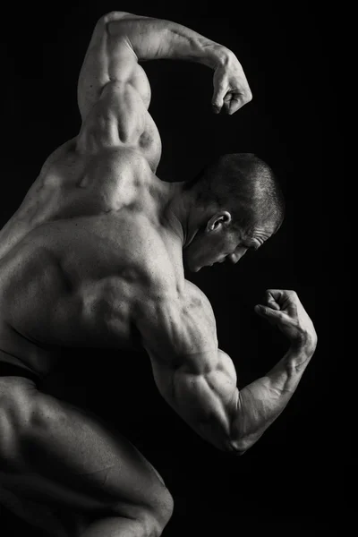 在黑色背景上的肌肉，救济健美。 — 图库照片