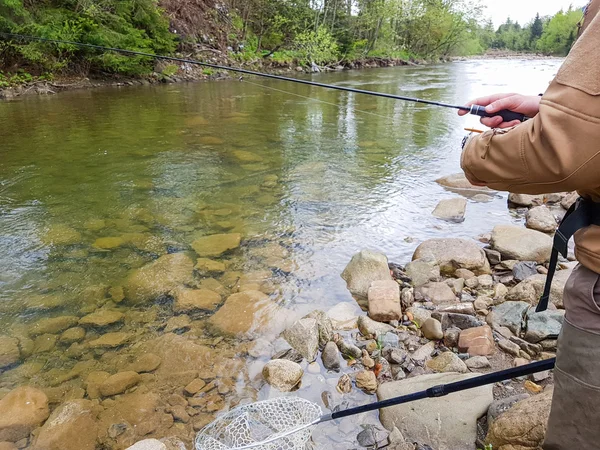 Fishing on the mountain river. Fisherman on the shore. Summer Ac — Stock Photo, Image