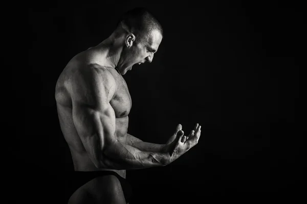 Muskulös, lättnad bodybuilder på svart bakgrund — Stockfoto