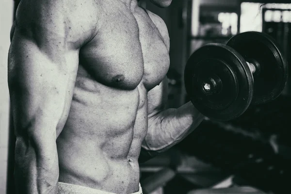 Occupazione con manubri in palestra. Uomo forte con i manubri — Foto Stock