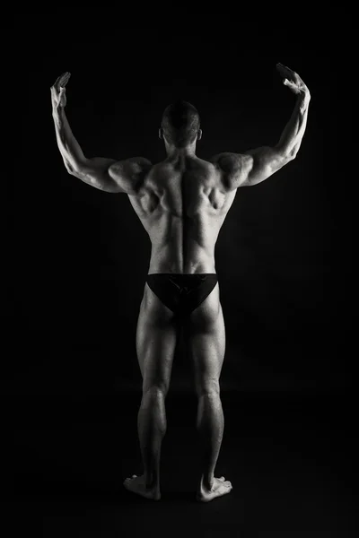 Muscular, levantador de pesas en relieve sobre un fondo negro —  Fotos de Stock