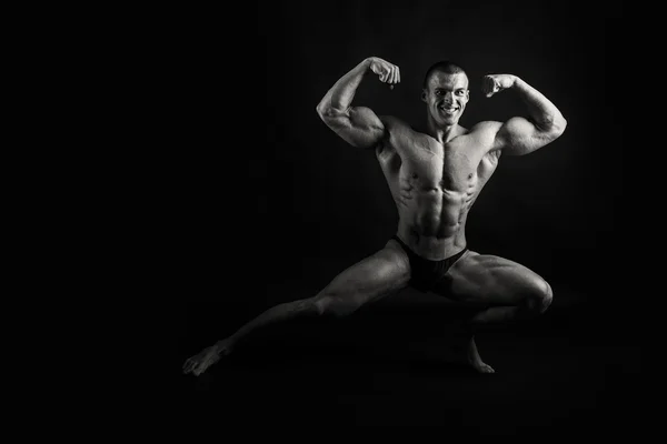 Muskulös, lättnad bodybuilder på svart bakgrund — Stockfoto