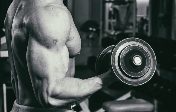 Occupation avec haltères dans la salle de gym. Homme fort avec haltères — Photo