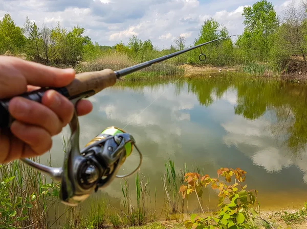 A pescar no lago. Carretel giratório e em um fundo de lago — Fotografia de Stock