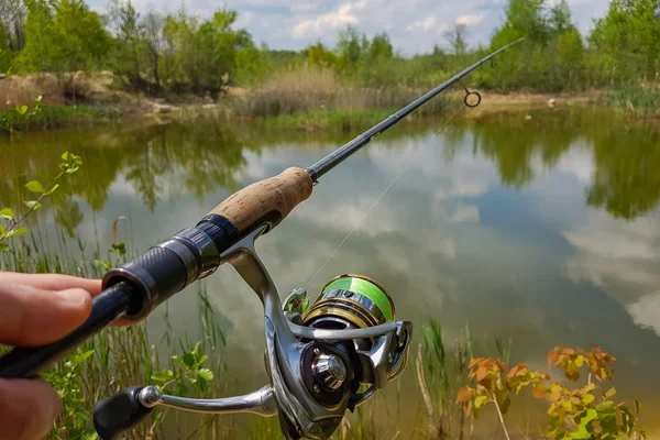 Рыбалка на озере. Вращающаяся катушка и на фоне озера — стоковое фото